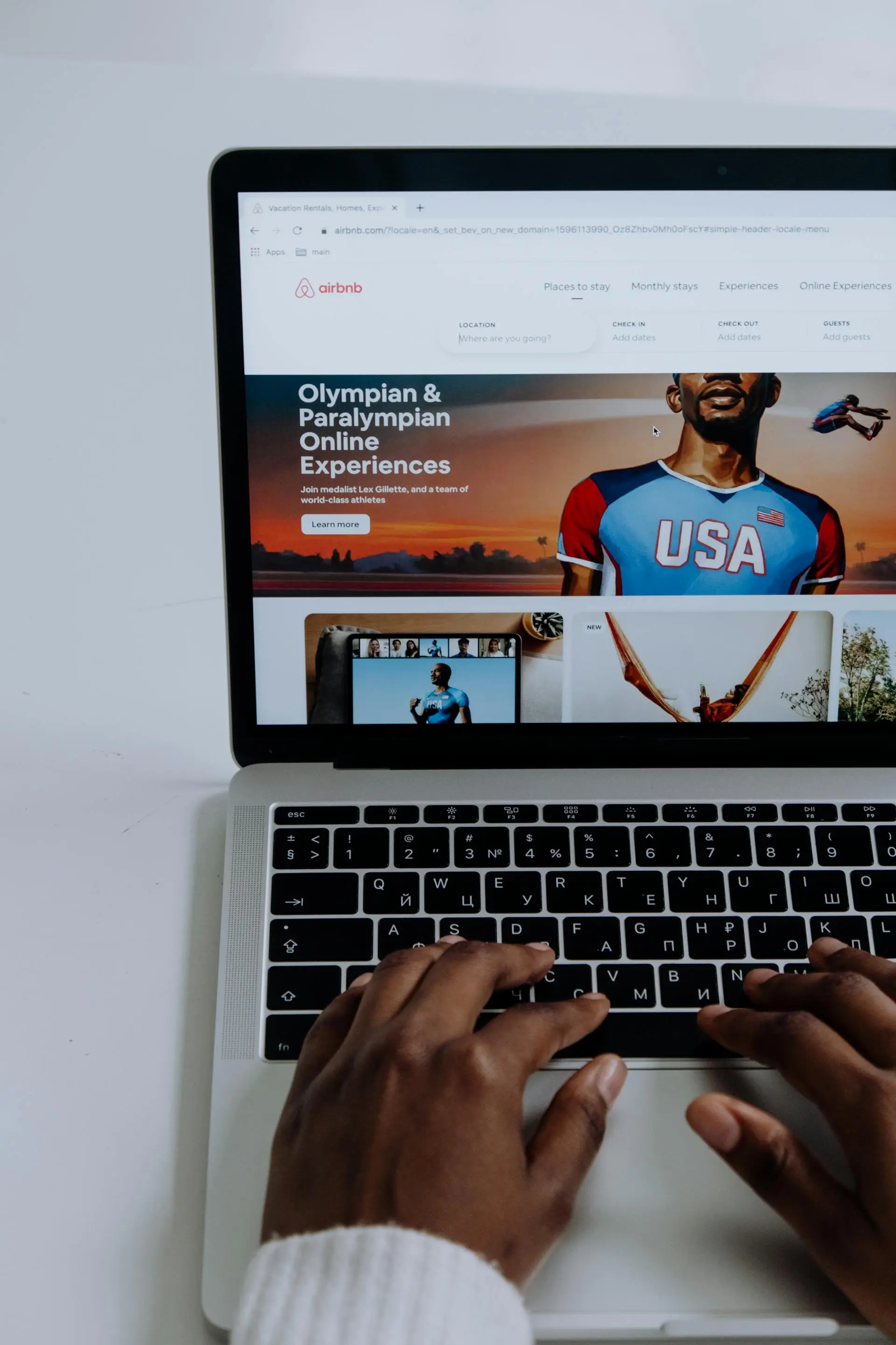Persona usando una laptop con la página web de Airbnb, buscando experiencias online con atletas olímpicos y paralímpicos.